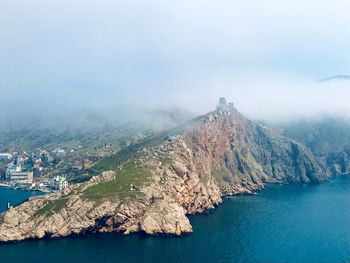Scenic view of sea and mountains against sky