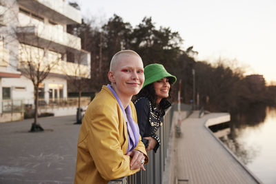 Smiling young women standing together at river