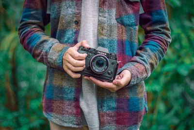 Midsection of man holding camera