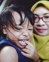 Close-up portrait of mother sitting with daughter in car