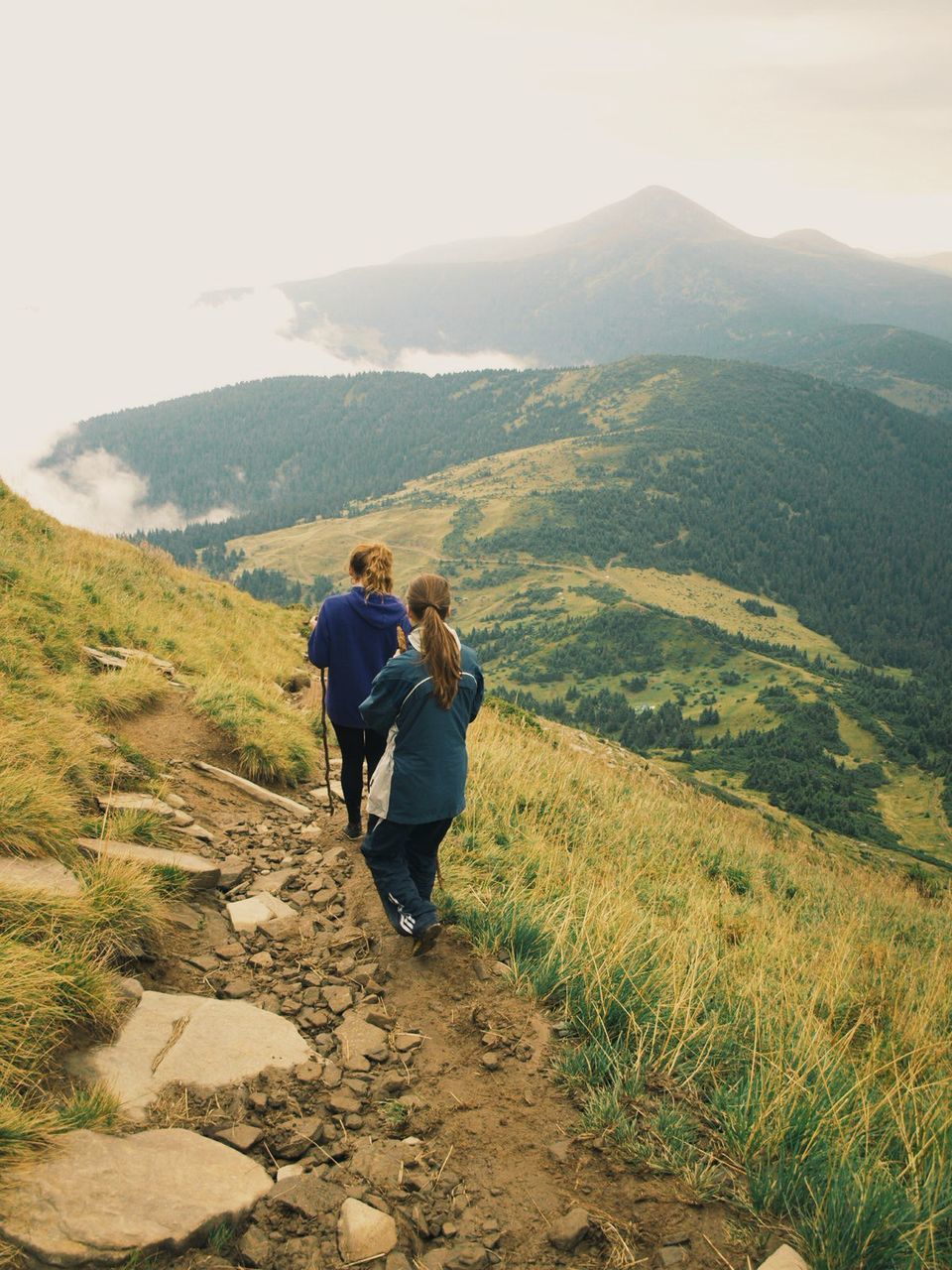 mountain, landscape, lifestyles, leisure activity, tranquil scene, tranquility, rear view, scenics, full length, men, beauty in nature, mountain range, grass, nature, sky, casual clothing, person, non-urban scene