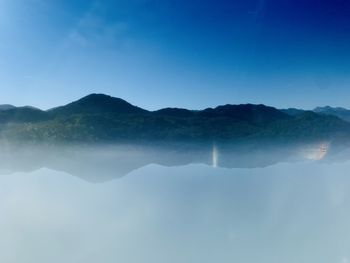 Scenic view of mountains against blue sky