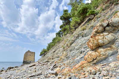 Rock formations on beach against sky