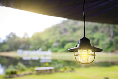 Close-up of electric lamp against sky