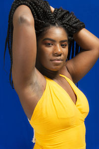 Young woman wearing colorful long clothes over blue background. natural expression.