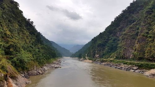 Scenic view of river amidst mountains against sky