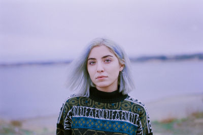 Portrait of beautiful woman standing against sky