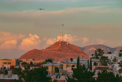 Buildings in city against cloudy sky