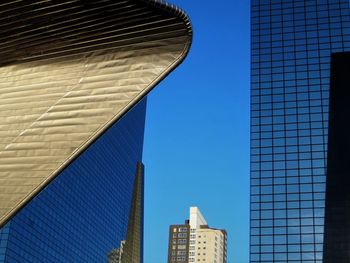 Low angle view of modern buildings against clear blue sky