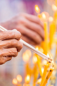 Close-up of hand lighting incenses