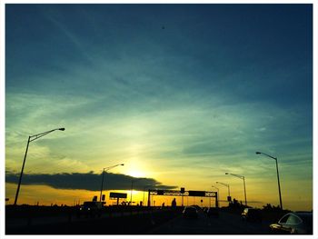 Silhouette of street light against sky at sunset