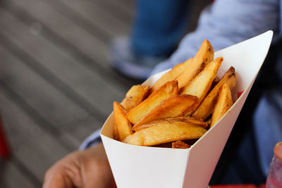 Cropped image of person holding french fries