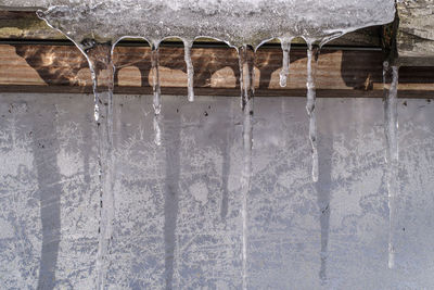 Close-up of icicles hanging against wall