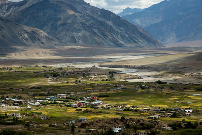 Scenic view of field and houses against mountains