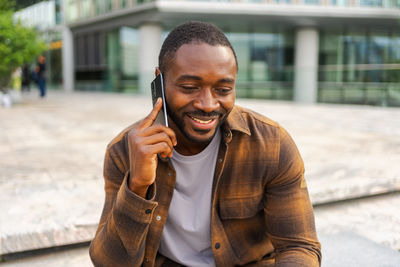 Portrait of young man looking away while standing outdoors