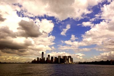 View of cityscape against cloudy sky