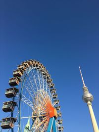 Low angle view of illuminated ferris wheel against blue sky