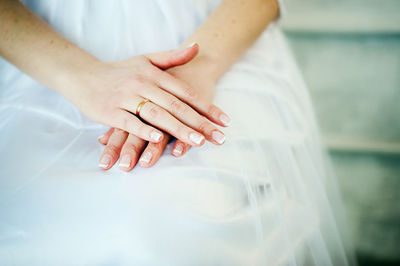 Midsection of bride sitting on chair