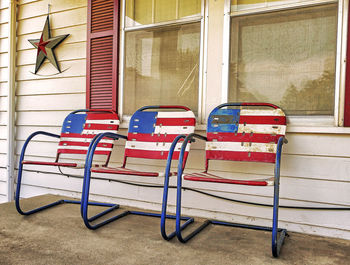 American flag painting on three chairs standing on porch