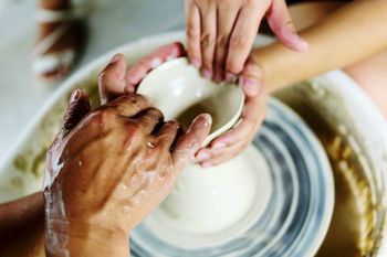 Cropped hands of women making pots