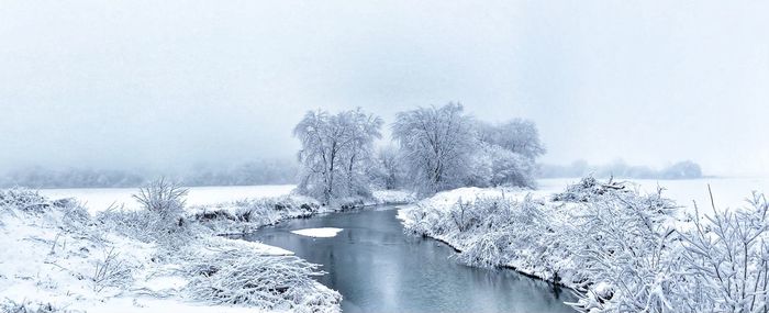 Scenic view of lake against sky during winter