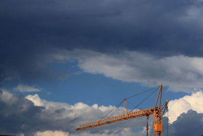 Low angle view of crane against sky
