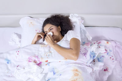 High angle view of woman lying on bed