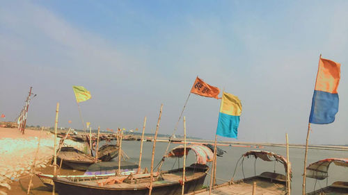 Sailboats moored in sea against sky