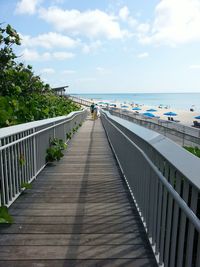 Boardwalk at beach against sky