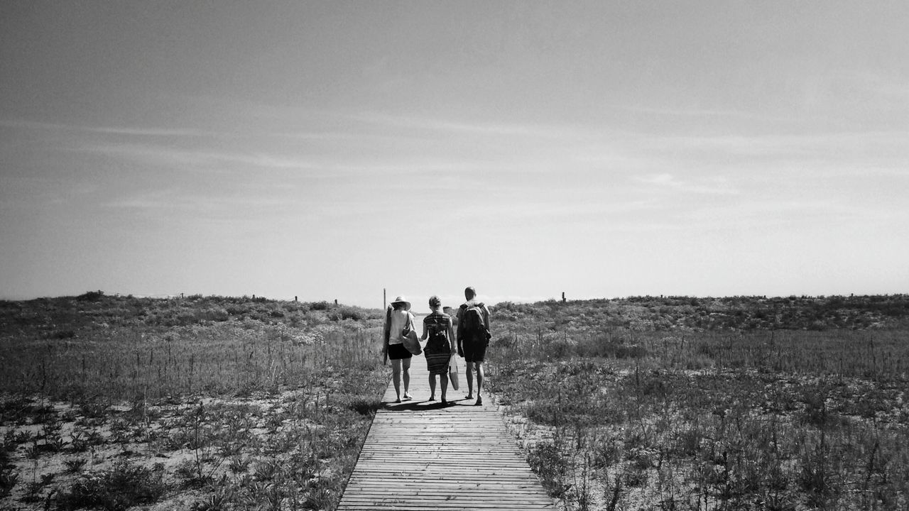 men, lifestyles, leisure activity, the way forward, person, sky, rear view, full length, walking, landscape, togetherness, grass, tranquility, nature, tranquil scene, scenics, bonding, field