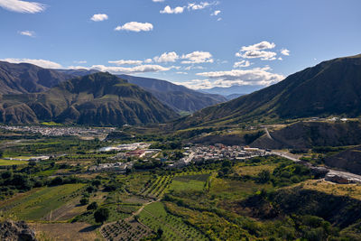 Scenic view of valley and mountains against sky