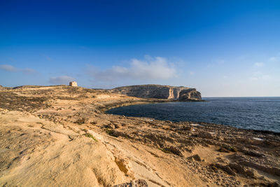 Scenic view of beach against blue sky