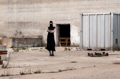 Side view of woman standing against wall