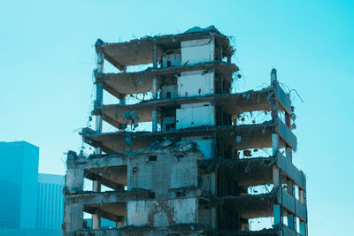 Low angle view of partly demolished building against sky