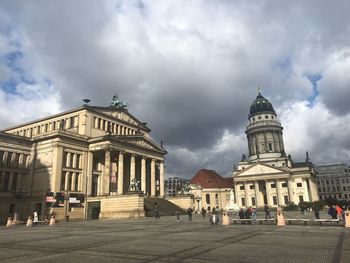 View of buildings in city against cloudy sky