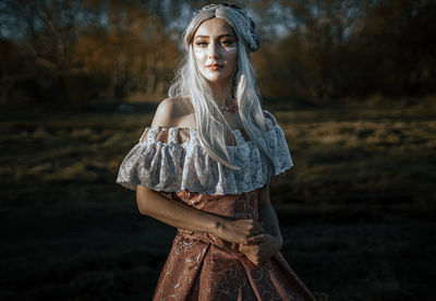 Portrait of young woman standing on tree