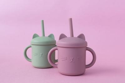 Pastel green and pink sippy cup with straw. silicone first soft cup for toddler. baby tableware
