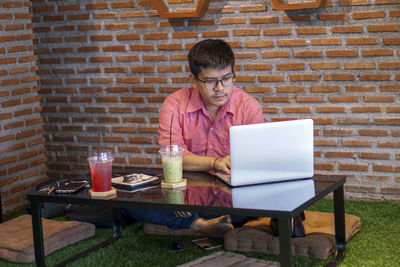 Full length of a man using laptop