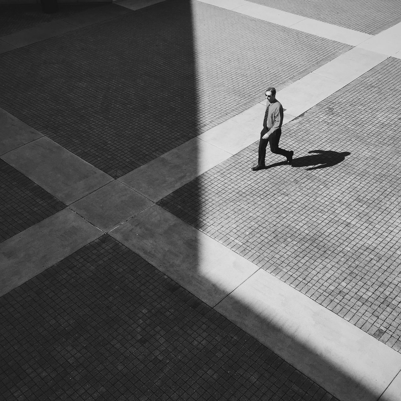 lifestyles, full length, leisure activity, men, shadow, walking, high angle view, indoors, sunlight, casual clothing, low section, person, rear view, on the move, standing, tiled floor