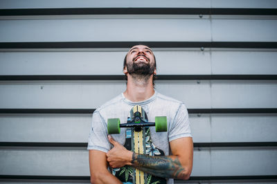 Boy posing with skateboard in hand