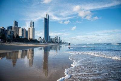 View of buildings at beach against cloudy sky