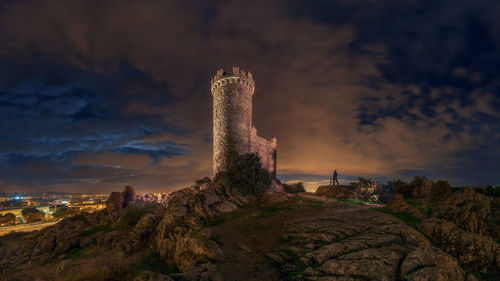 View of castle against cloudy sky at night
