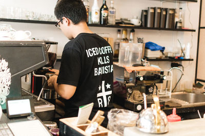 Rear view of man working at cafe