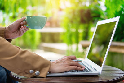 Close-up of woman using mobile phone on table