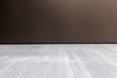 Empty wooden floor against wall at home