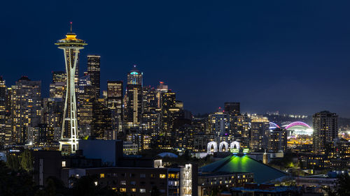 Illuminated cityscape against sky at night