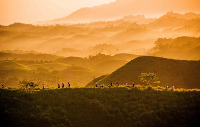 Group of people on field against mountain range