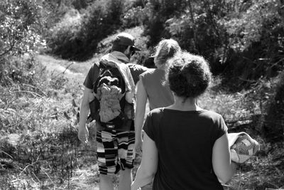 Rear view of woman sitting on tree stump