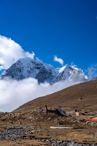 Scenic view of snowcapped mountains against blue sky