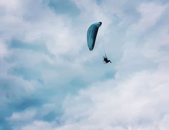 Low angle view of person paragliding against sky